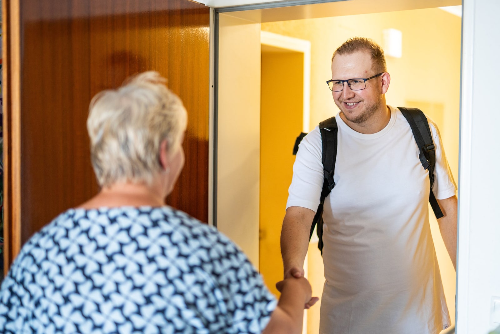 Jan Schlösser begrüßt eine Kundin an ihrer Wohnungstür