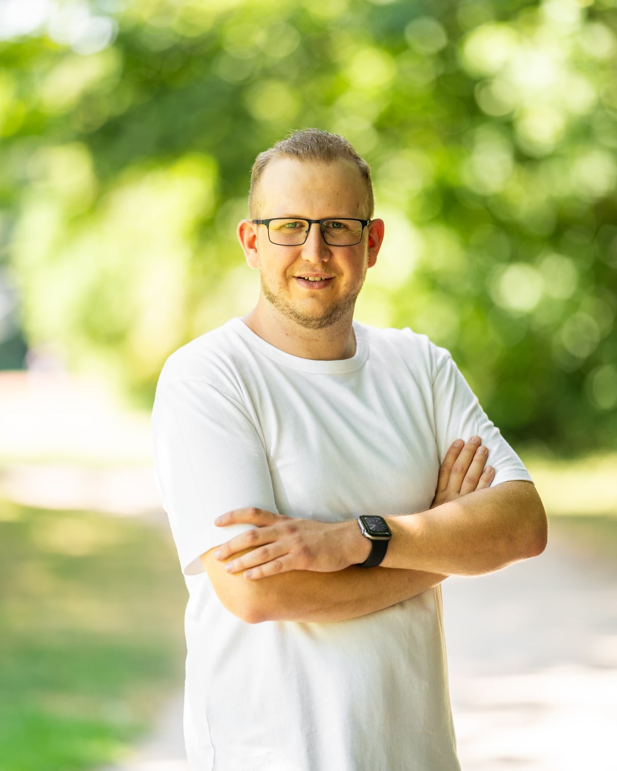 Jan Schlösser steht lächelnd in einem Park