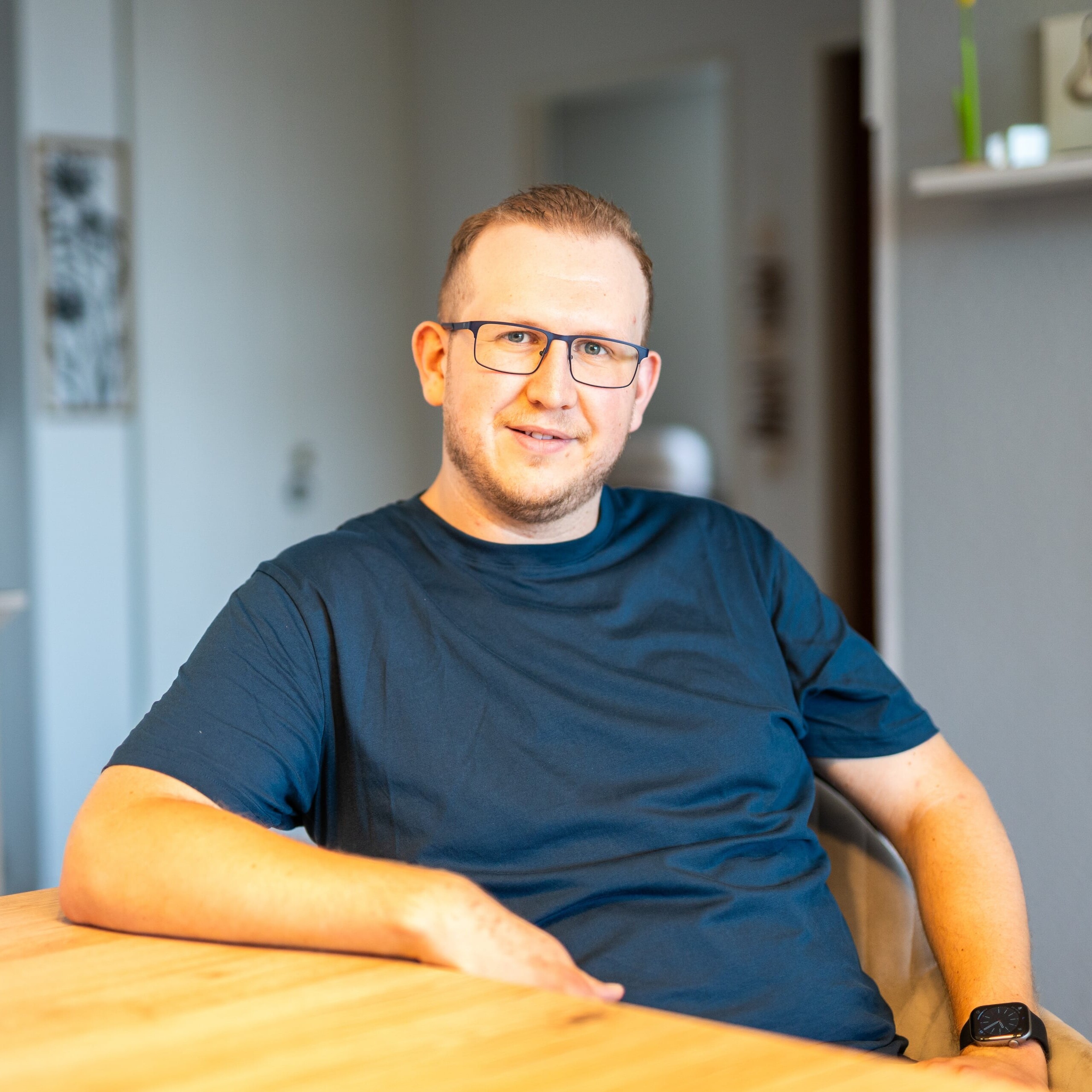 Jan Schlösser sitzt an einem Esstisch und blickt freundlich in die Kamera