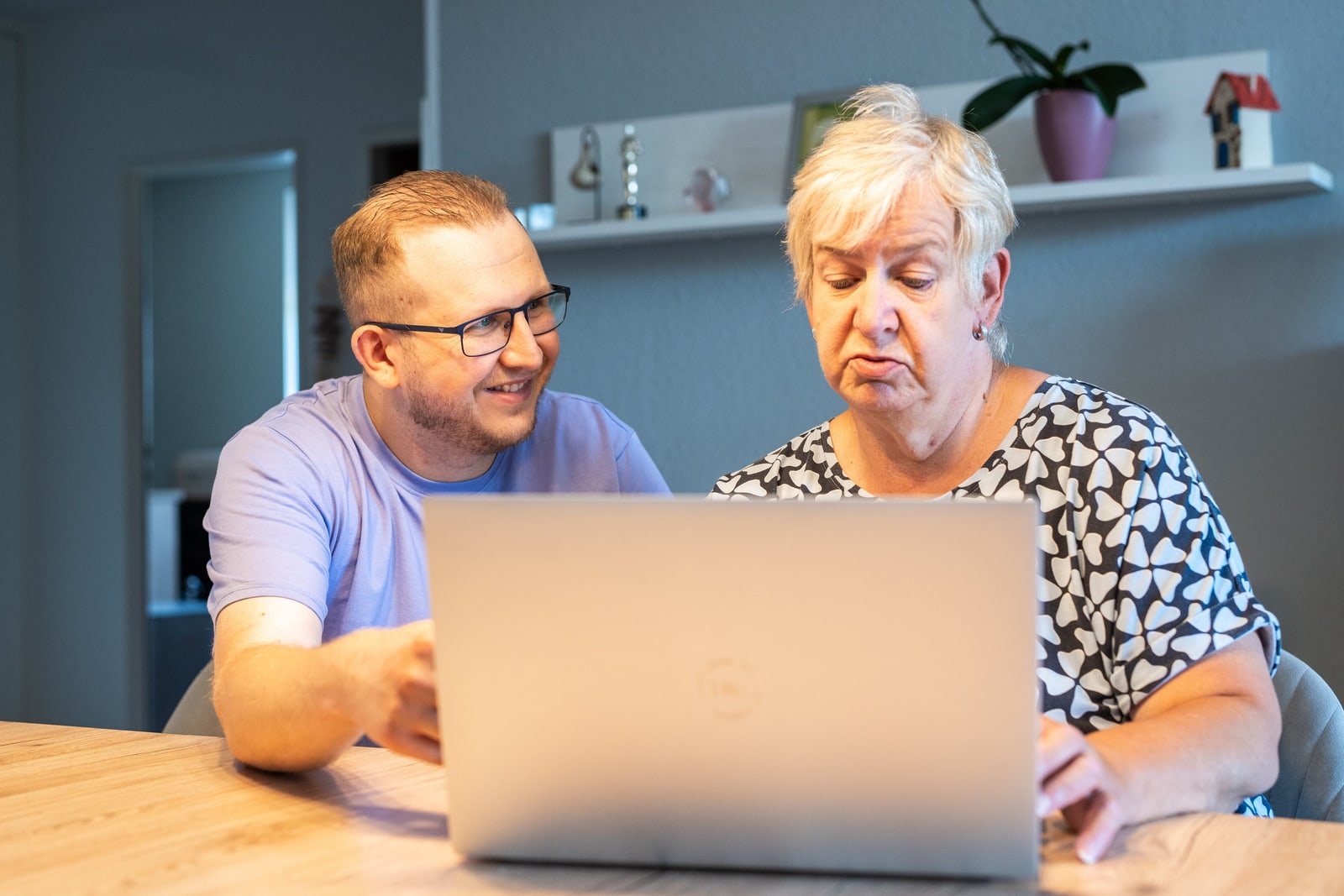 Jan Schlösser und eine Kundin schauen gemeinsam auf einen Laptop