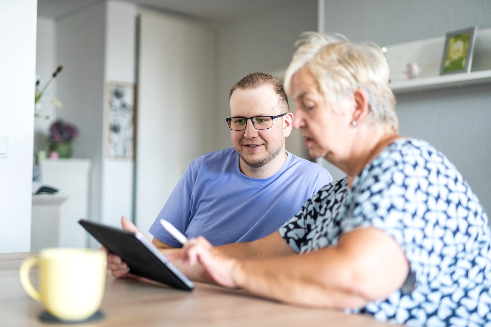 Jan Schlösser erklärt einer Kundin die Bedienung eines Tablets