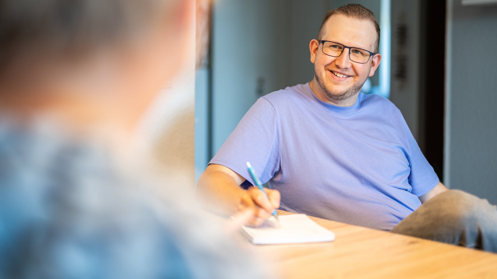 Jan Schlösser macht im Gespräch mit einer Kundin Notizen